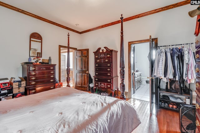 bedroom featuring ensuite bathroom, light hardwood / wood-style flooring, and ornamental molding