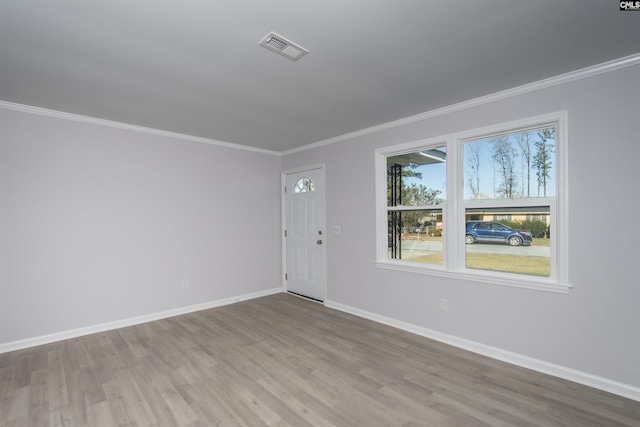 empty room featuring hardwood / wood-style floors and ornamental molding