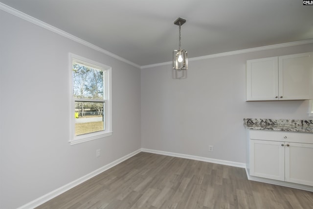 unfurnished dining area featuring crown molding and light hardwood / wood-style floors