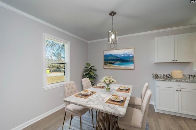 dining area with crown molding and light hardwood / wood-style flooring