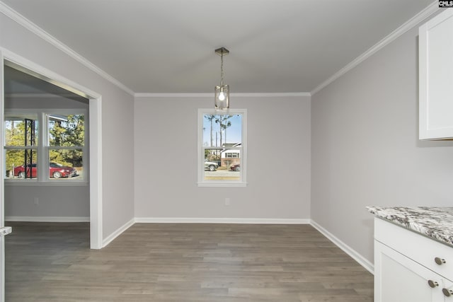 unfurnished dining area with hardwood / wood-style floors, a healthy amount of sunlight, and ornamental molding