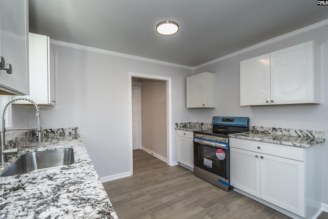 kitchen featuring stainless steel range, light stone counters, white cabinetry, and sink