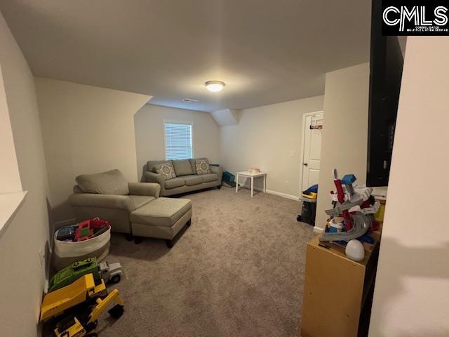 carpeted living room featuring vaulted ceiling