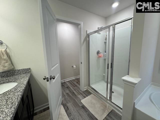 bathroom featuring hardwood / wood-style floors, vanity, and separate shower and tub