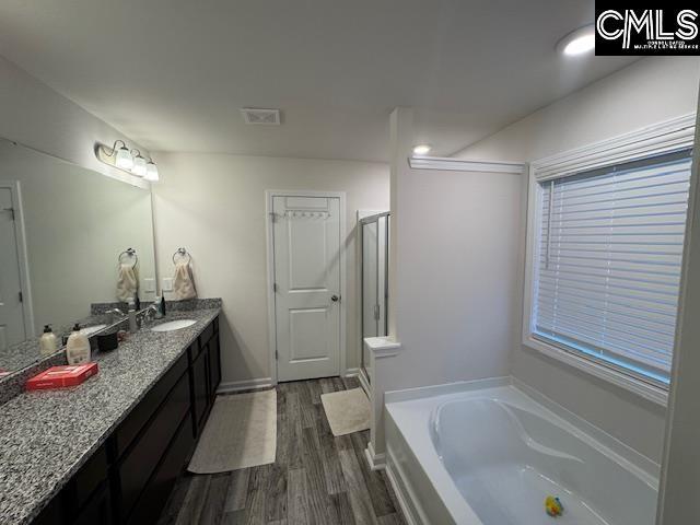 bathroom featuring separate shower and tub, hardwood / wood-style floors, and vanity