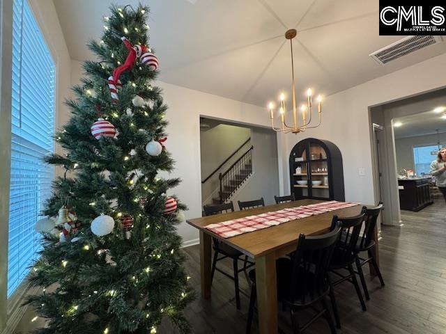 dining space featuring hardwood / wood-style floors and an inviting chandelier