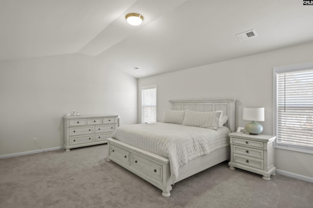 bedroom featuring light carpet and vaulted ceiling