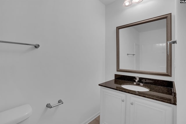 bathroom featuring tile patterned flooring, vanity, and toilet