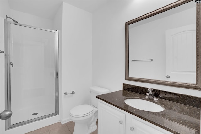 bathroom featuring toilet, vanity, tile patterned floors, and an enclosed shower