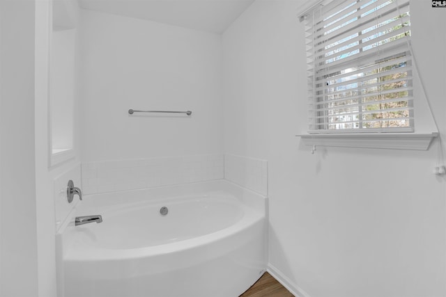 bathroom featuring a bath, plenty of natural light, and hardwood / wood-style floors