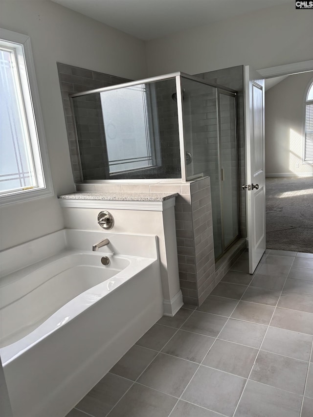 bathroom featuring tile patterned flooring, shower with separate bathtub, and a wealth of natural light