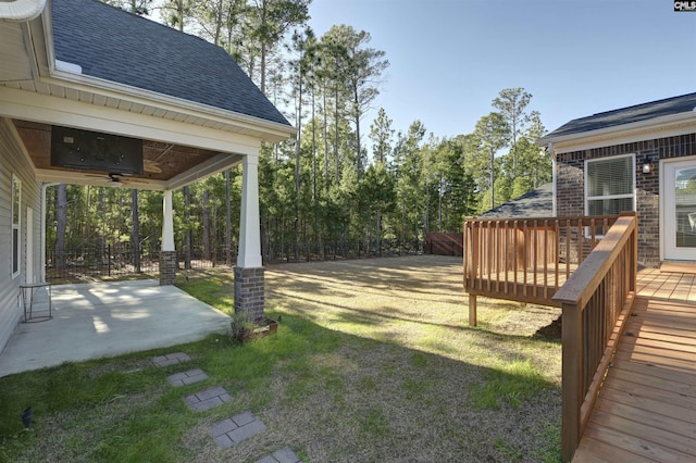 view of yard with ceiling fan and a wooden deck