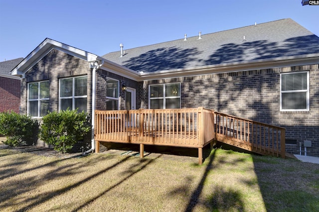 rear view of house featuring a wooden deck and a yard