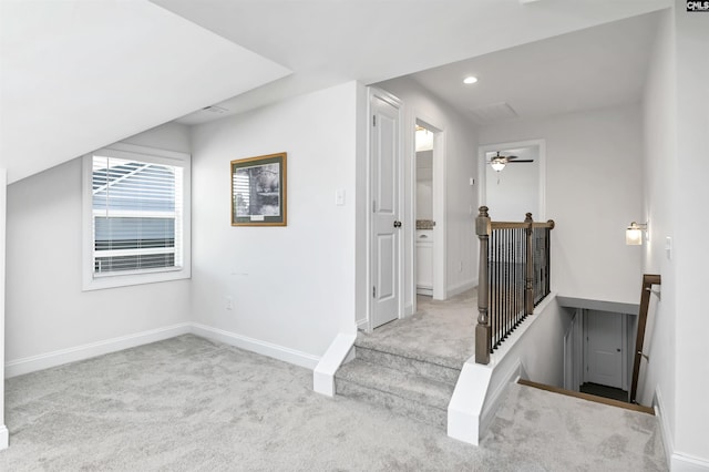 interior space featuring ceiling fan, light colored carpet, and vaulted ceiling