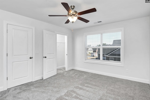 unfurnished bedroom with ceiling fan and light colored carpet