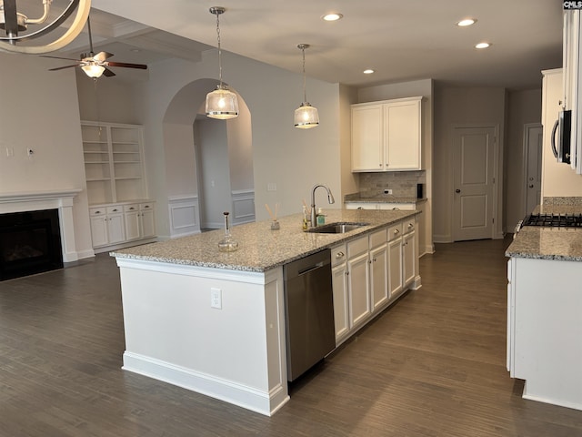 kitchen with stainless steel appliances, a kitchen island with sink, sink, beam ceiling, and white cabinets