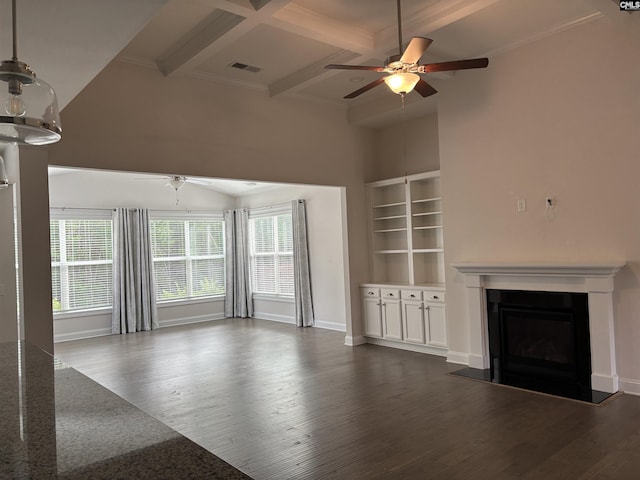 unfurnished living room featuring coffered ceiling, dark hardwood / wood-style floors, ceiling fan, built in features, and beam ceiling