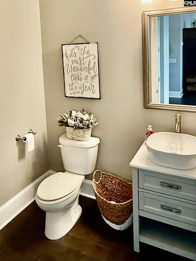 bathroom featuring toilet, hardwood / wood-style flooring, and vanity