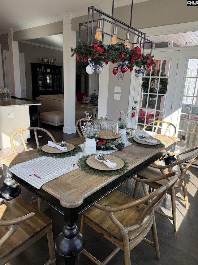 dining space with decorative columns, hardwood / wood-style flooring, and ornamental molding