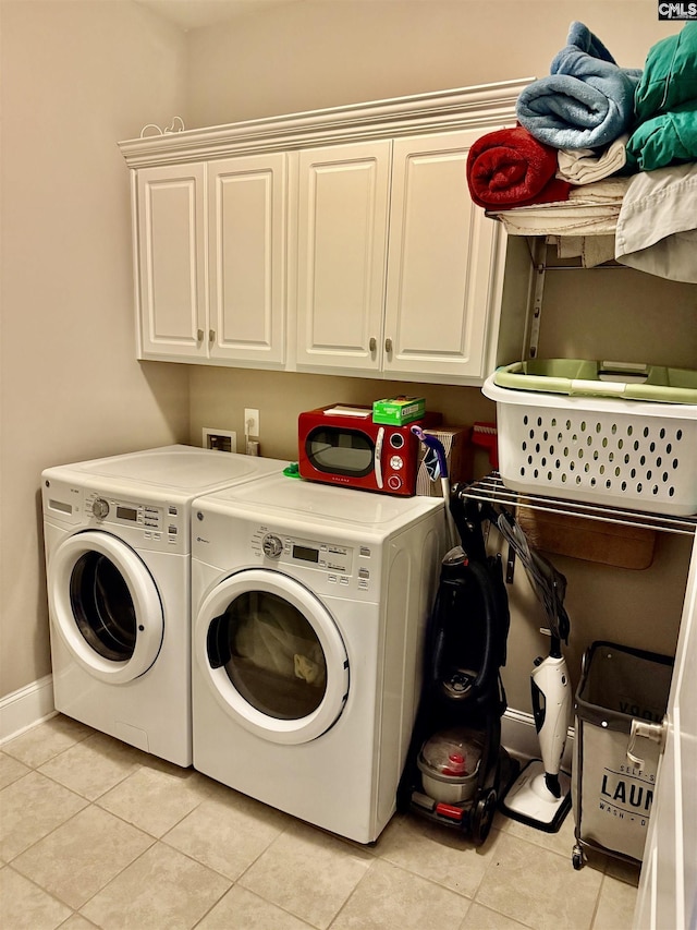 washroom featuring cabinets, light tile patterned floors, and separate washer and dryer