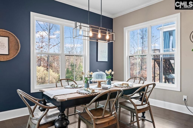 dining area featuring dark hardwood / wood-style flooring, crown molding, and a chandelier