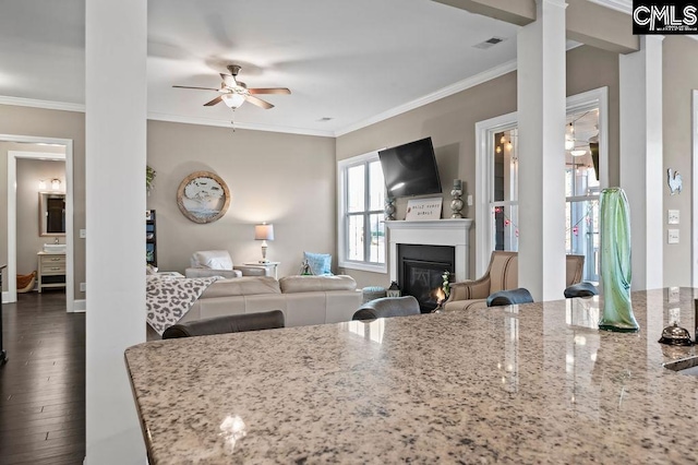 kitchen featuring ceiling fan, light stone countertops, ornamental molding, and dark wood-type flooring