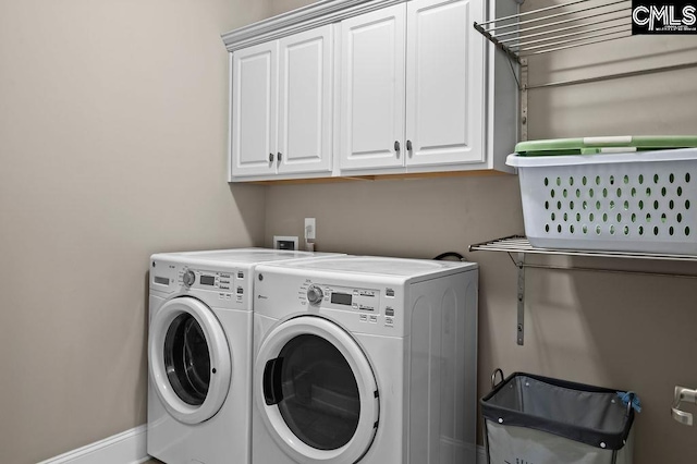 clothes washing area featuring washing machine and clothes dryer and cabinets