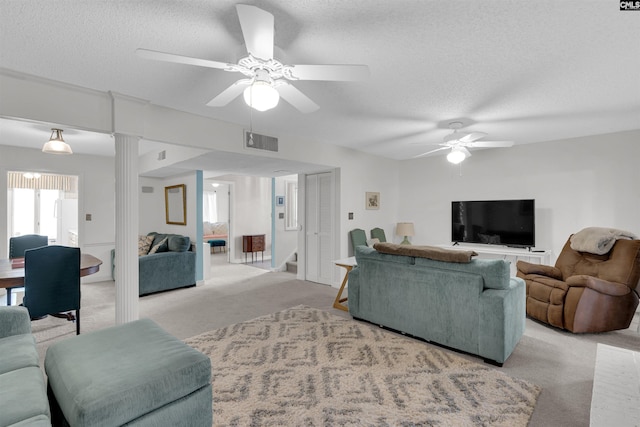 carpeted living room featuring ceiling fan and a textured ceiling