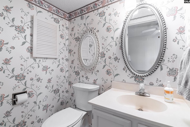 bathroom featuring vanity, a textured ceiling, and toilet