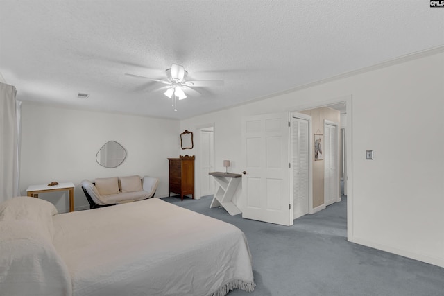 carpeted bedroom with ceiling fan, crown molding, and a textured ceiling