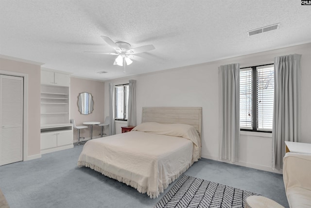 bedroom with light carpet, a textured ceiling, and ceiling fan