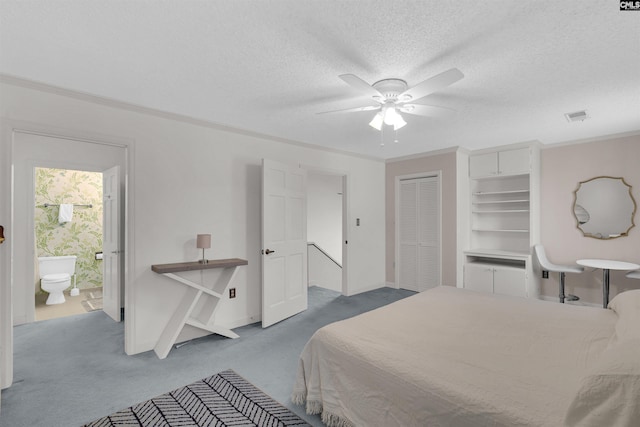 carpeted bedroom featuring ceiling fan, ornamental molding, a textured ceiling, connected bathroom, and a closet