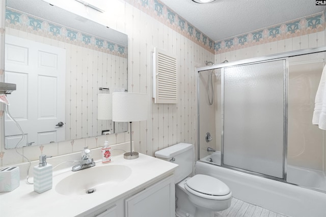 full bathroom with vanity, toilet, enclosed tub / shower combo, and a textured ceiling