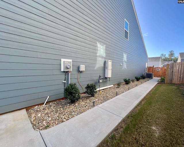 view of side of home featuring central air condition unit and a yard