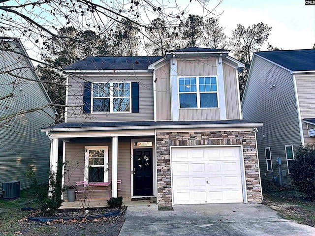 view of front facade with central AC unit, a garage, and covered porch