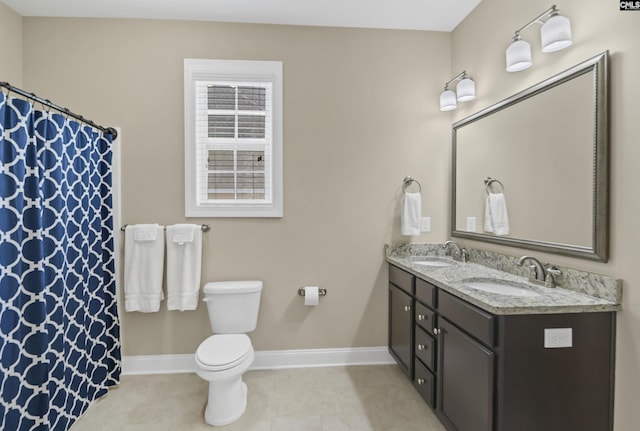 bathroom with tile patterned flooring, vanity, and toilet