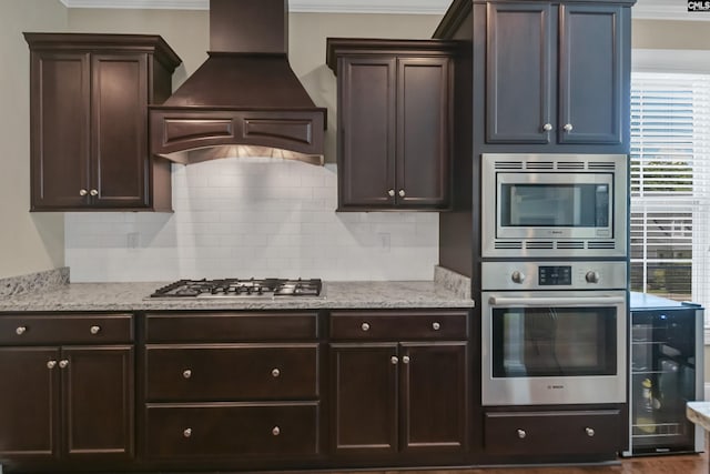 kitchen featuring custom exhaust hood, wine cooler, ornamental molding, and appliances with stainless steel finishes