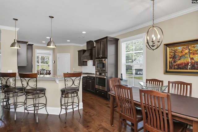 dining space with dark hardwood / wood-style floors, ornamental molding, and a notable chandelier