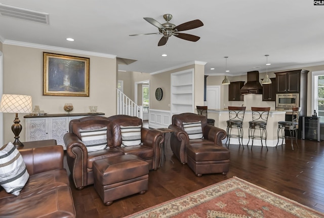 living room with crown molding, plenty of natural light, ceiling fan, and dark hardwood / wood-style floors