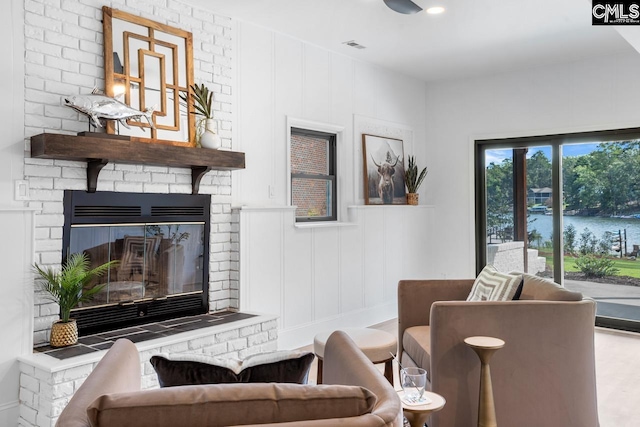 living room featuring a fireplace and a water view