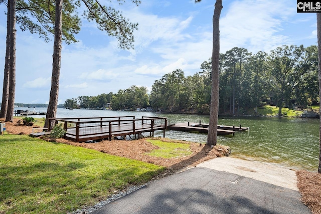 view of dock featuring a lawn and a water view