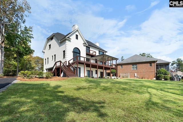 rear view of house featuring a lawn and a wooden deck