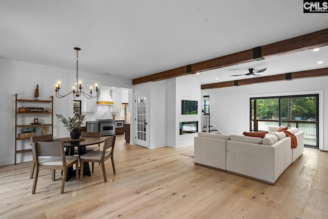 dining space featuring ceiling fan with notable chandelier, beam ceiling, light wood-type flooring, and a fireplace