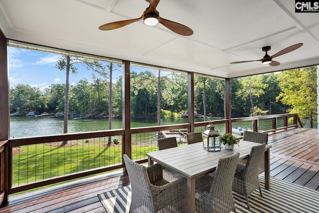 sunroom featuring a water view and ceiling fan