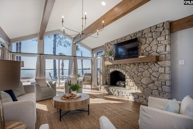 living room featuring a stone fireplace, a water view, hardwood / wood-style flooring, beam ceiling, and a chandelier