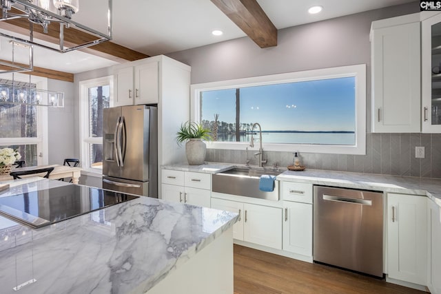 kitchen with white cabinetry, sink, beamed ceiling, and appliances with stainless steel finishes