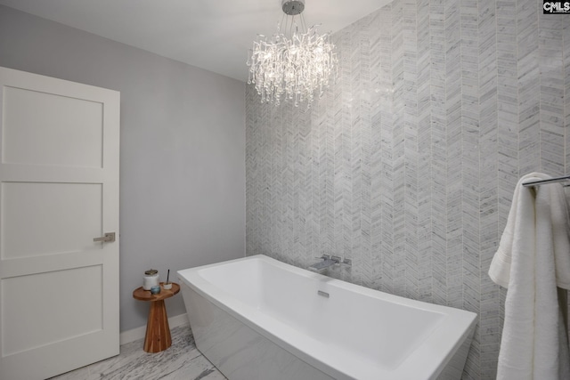 bathroom featuring a bathtub and a notable chandelier