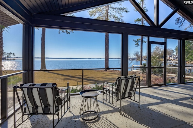 sunroom featuring a wealth of natural light, a water view, and lofted ceiling