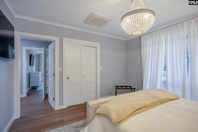 bedroom with dark hardwood / wood-style flooring, an inviting chandelier, and ornamental molding