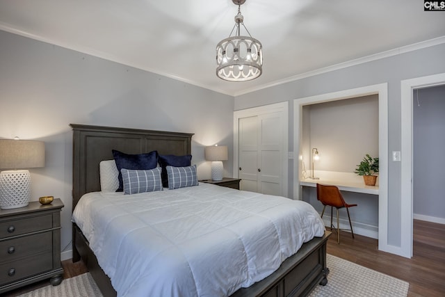 bedroom with a notable chandelier, dark hardwood / wood-style floors, and crown molding